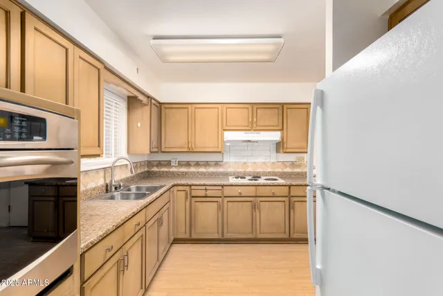 a kitchen with stainless steel appliances a sink stove and cabinets