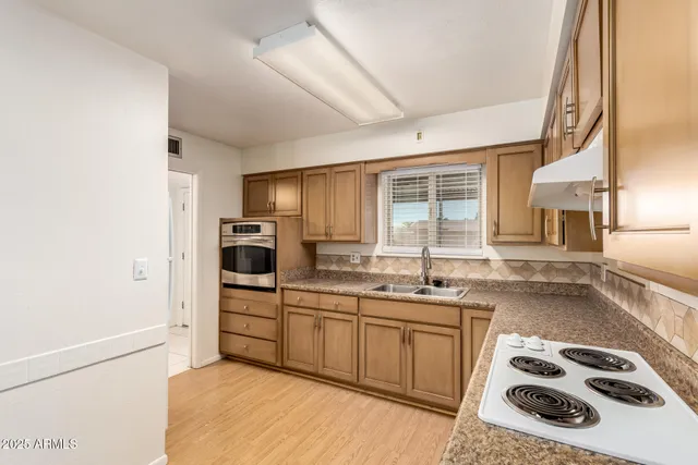 a kitchen with a sink a stove and cabinets