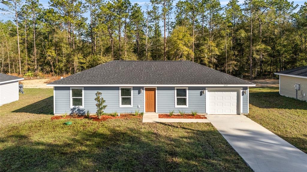 6 Southwest Tree Top Road Dunnellon, FL 34431 - Photo 1 of 1 a front view of house with yard and trees in the background