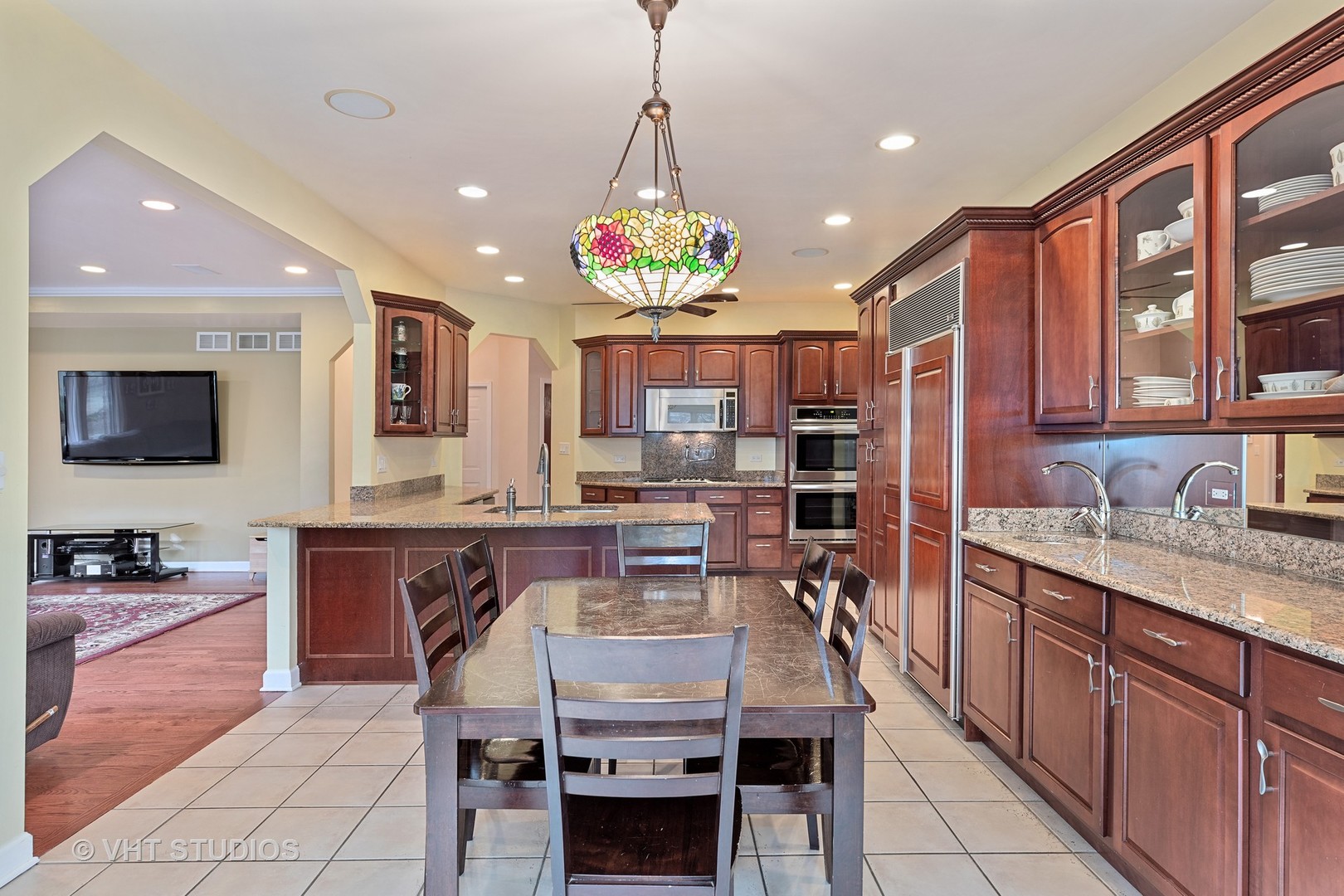 2126 Pine Road Homewood, IL 60430 - Photo 8 of 22 a kitchen with granite countertop lots of wooden cabinets stainless steel appliances a dining table and chairs