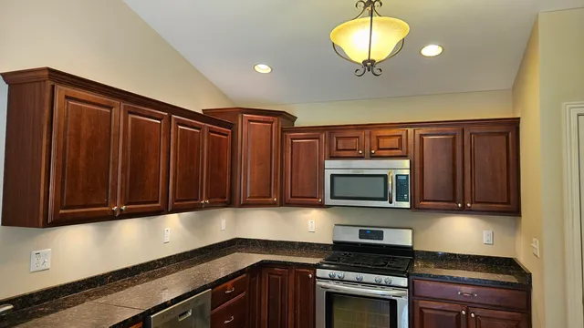 a kitchen with stainless steel appliances granite countertop a stove and a microwave