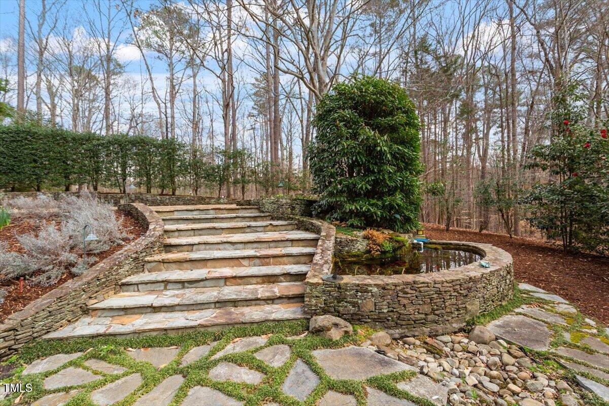 10729 Trego Trail Raleigh, NC 27614 - Photo 55 of 65 A koi pond is adjacent to the stone staircase that leads to the pool