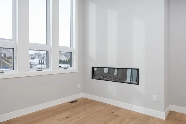 a view of an empty room with window and cabinet