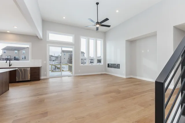 a large kitchen with stainless steel appliances a large counter top a sink and a refrigerator