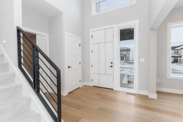 a view of hallway with stairs and wooden floor