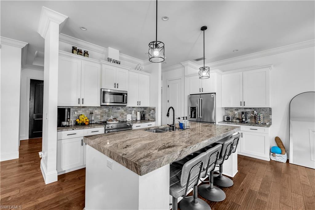 11141 Palmetto Ridge Drive Naples, FL 34110 - Photo 18 of 31 a kitchen with a table chairs stove and refrigerator