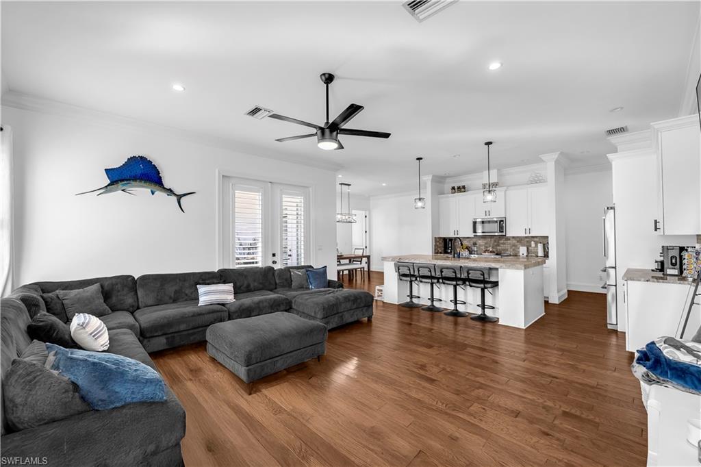 11141 Palmetto Ridge Drive Naples, FL 34110 - Photo 23 of 31 a living room with furniture a wooden floor and a chandelier