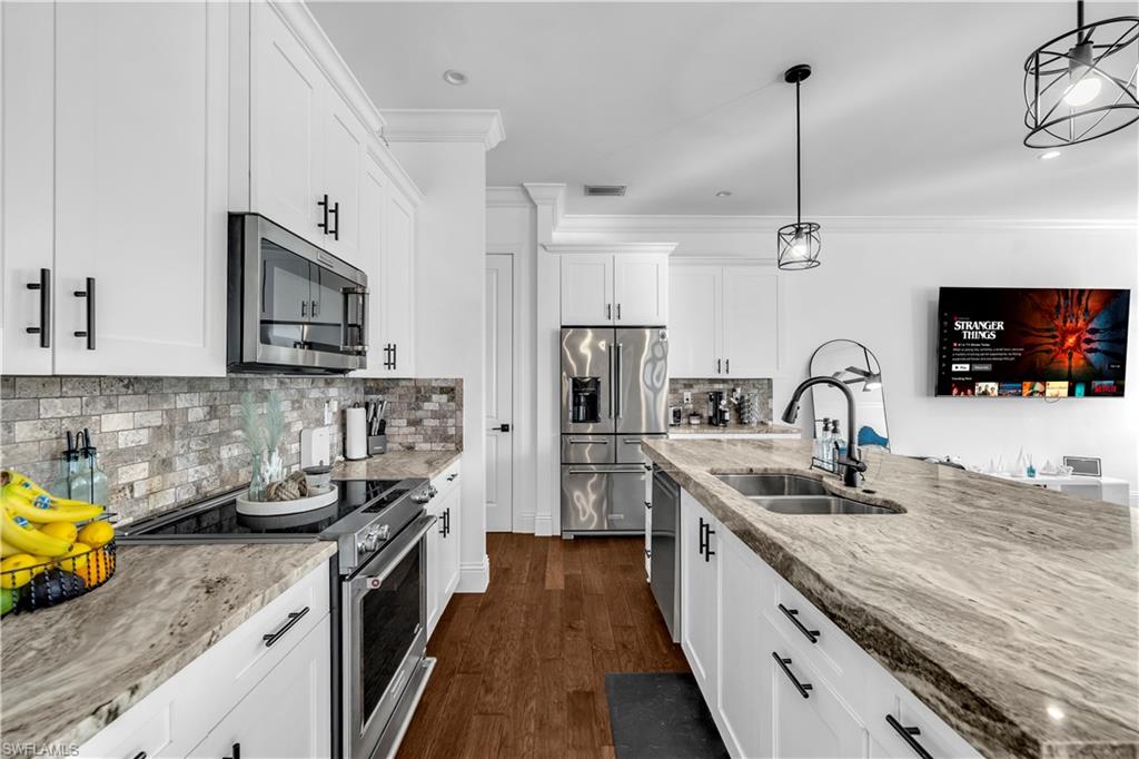 11141 Palmetto Ridge Drive Naples, FL 34110 - Photo 24 of 31 a kitchen with stainless steel appliances granite countertop a sink stove and refrigerator