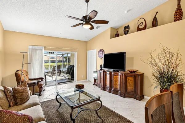 a living room with couches a coffee table and piano table with wooden floor