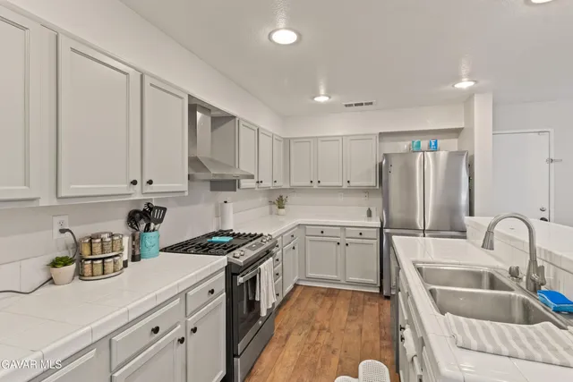 a kitchen with granite countertop a sink stainless steel appliances and cabinets