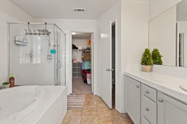 a bathroom with a tub shower vanity and a sink