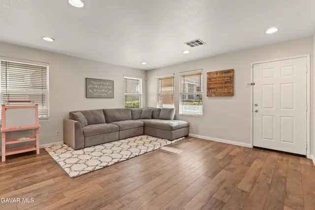 a living room with furniture and wooden floor