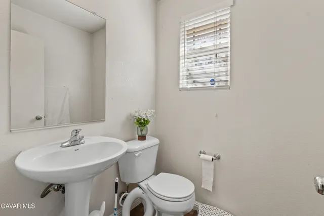 a bathroom with a sink a toilet and mirror