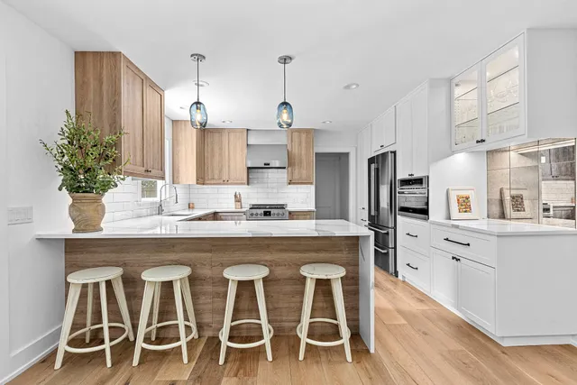a kitchen with cabinets a sink and chairs