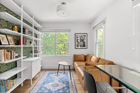 a living room with furniture and a book shelf
