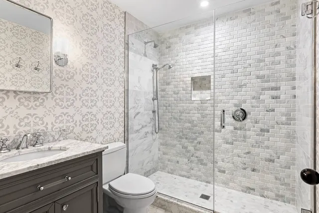 a bathroom with a shower toilet and sink