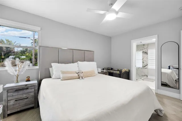 a bedroom with a bed and large windows