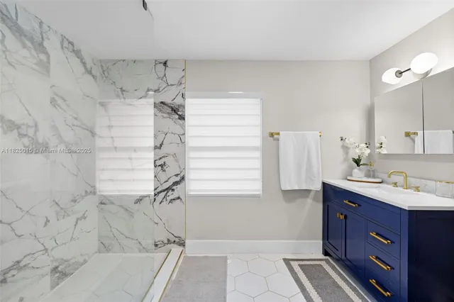 a bathroom with a granite countertop sink a toilet and shower
