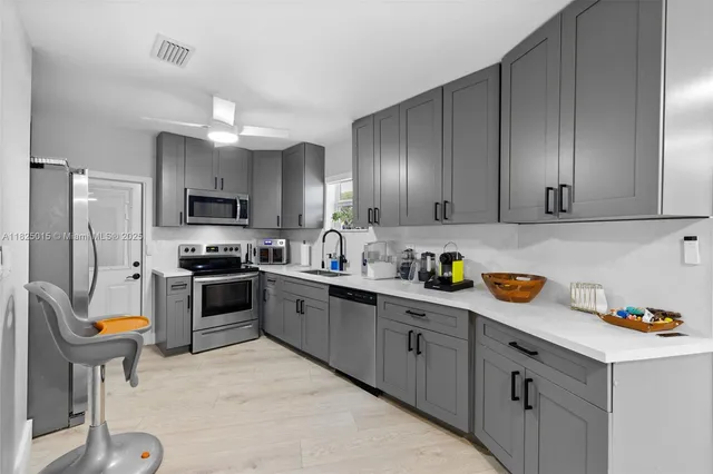 a kitchen with stainless steel appliances granite countertop a refrigerator stove microwave and sink