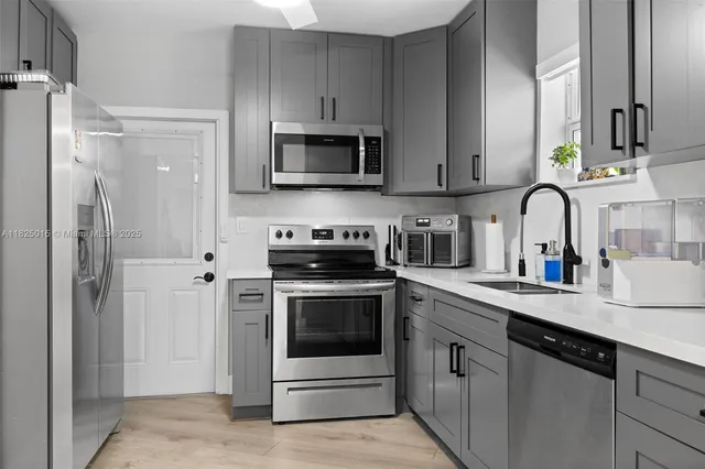 a kitchen with stainless steel appliances granite countertop a sink stove and refrigerator