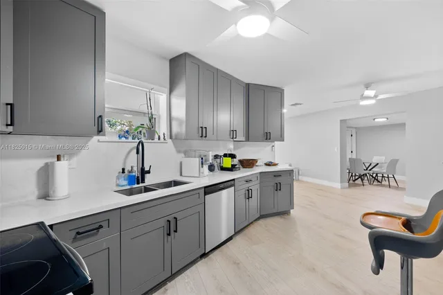 a kitchen with kitchen island granite countertop a sink a counter space appliances and cabinets