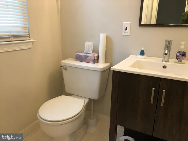 a bathroom with a sink a toilet and a mirror