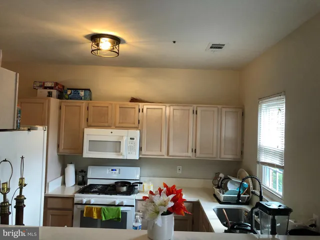 a kitchen with a refrigerator and a stove top oven