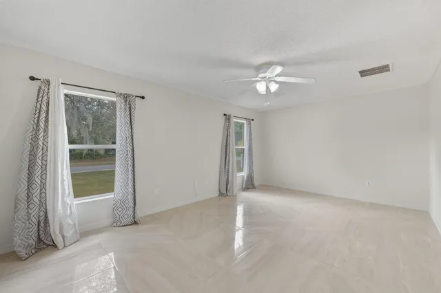a view of a room with a ceiling fan and a window
