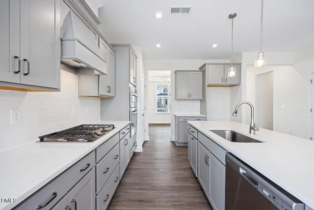 a kitchen with kitchen island stainless steel appliances a sink stove and cabinets
