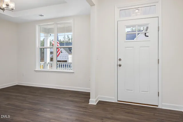 an empty room with wooden floor and painting on the wall