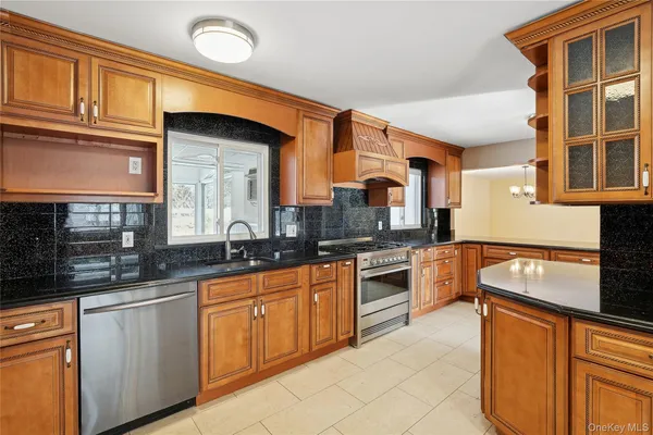 a large kitchen with stainless steel appliances granite countertop a stove a sink and a microwave