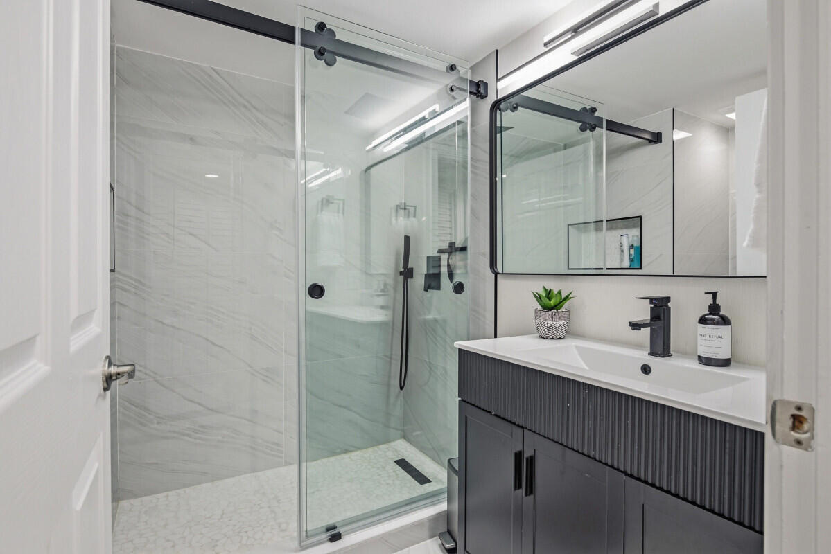 17372 Boca Club Boulevard, Unit 408 Boca Raton, FL 33487 - Photo 11 of 18 a bathroom with a sink shower and a mirror