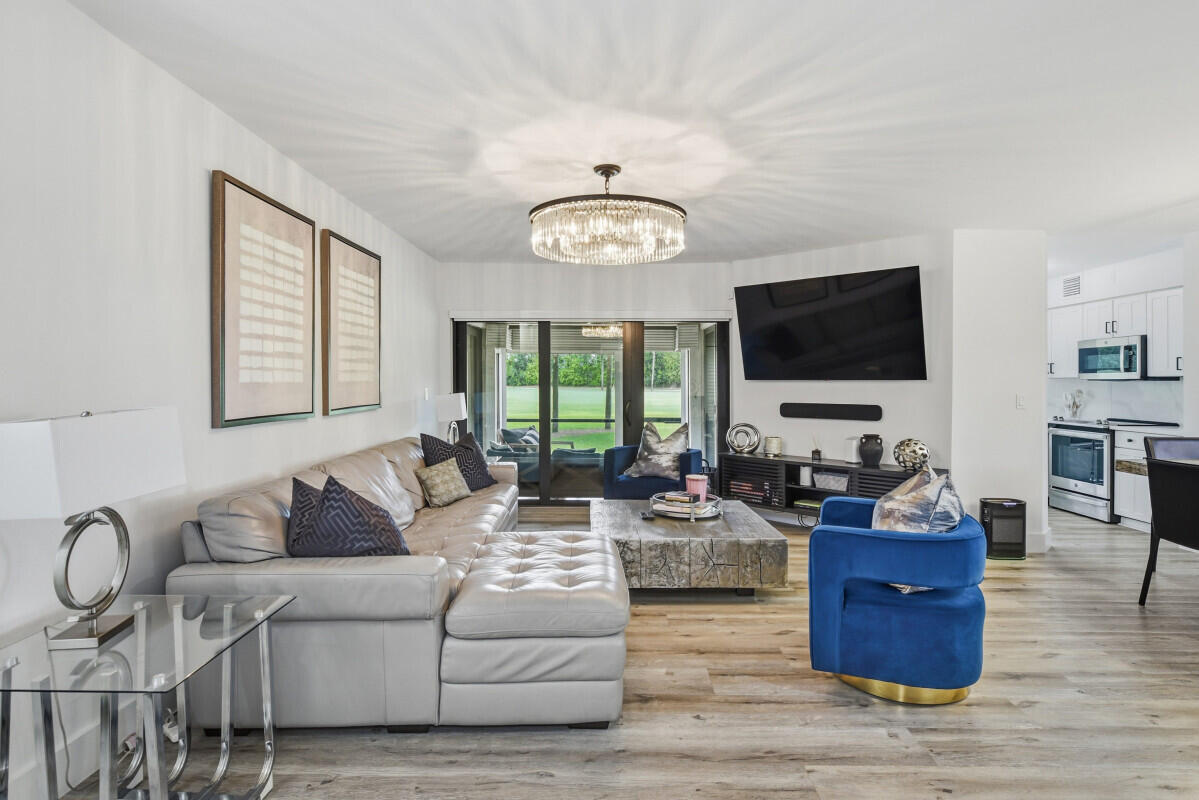 17372 Boca Club Boulevard, Unit 408 Boca Raton, FL 33487 - Photo 2 of 18 a living room with furniture and a flat screen tv