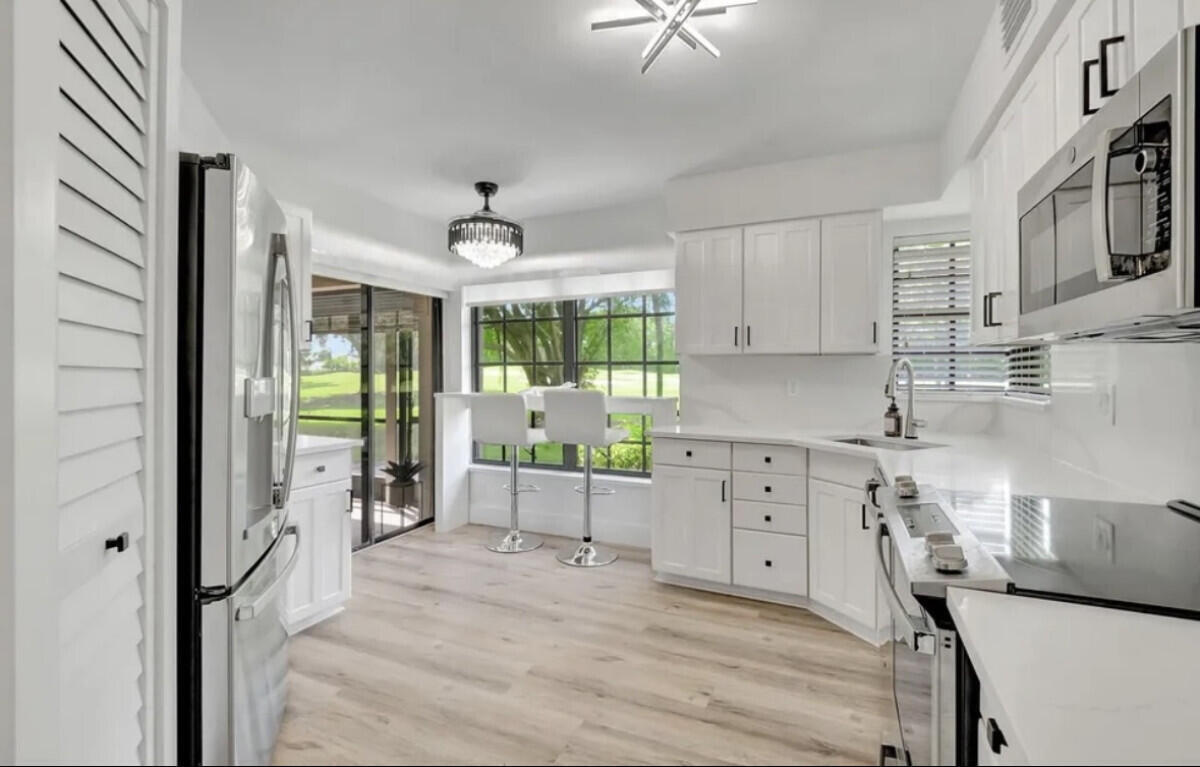 17372 Boca Club Boulevard, Unit 408 Boca Raton, FL 33487 - Photo 4 of 18 a kitchen with cabinets a sink and appliances