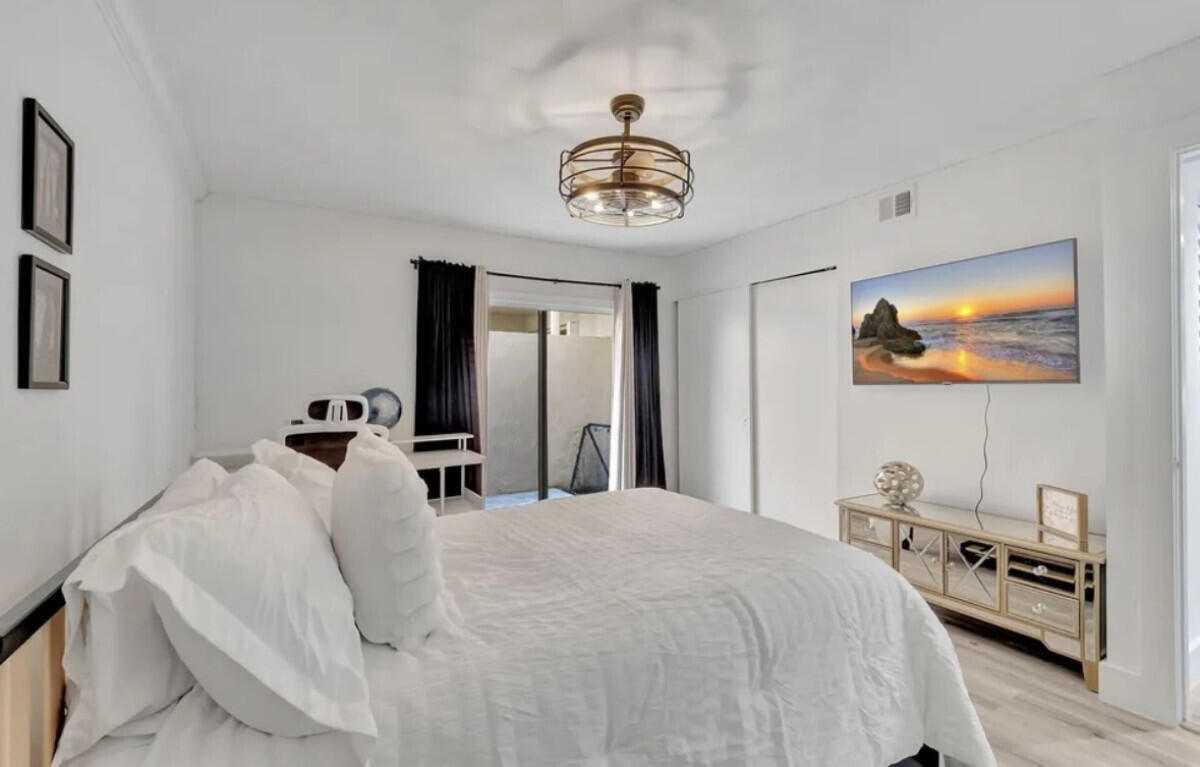 17372 Boca Club Boulevard, Unit 408 Boca Raton, FL 33487 - Photo 9 of 18 a bedroom with a bed and a chandelier