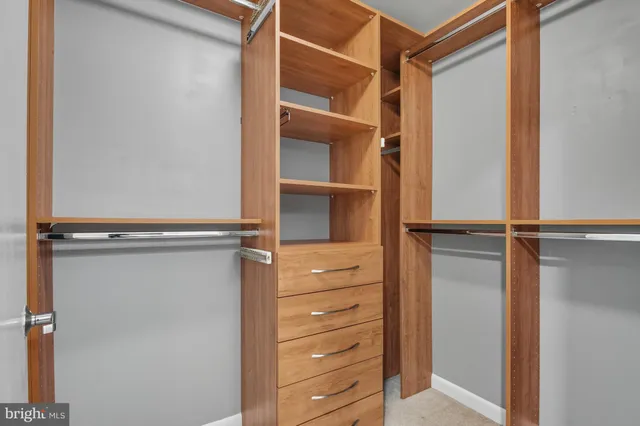 a view of walk in closet with empty racks