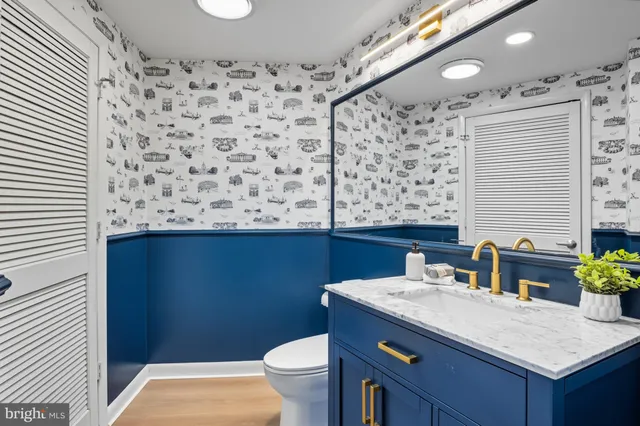 a bathroom with a granite countertop sink and a toilet