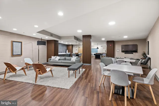 a living room with furniture a flat screen tv and kitchen view