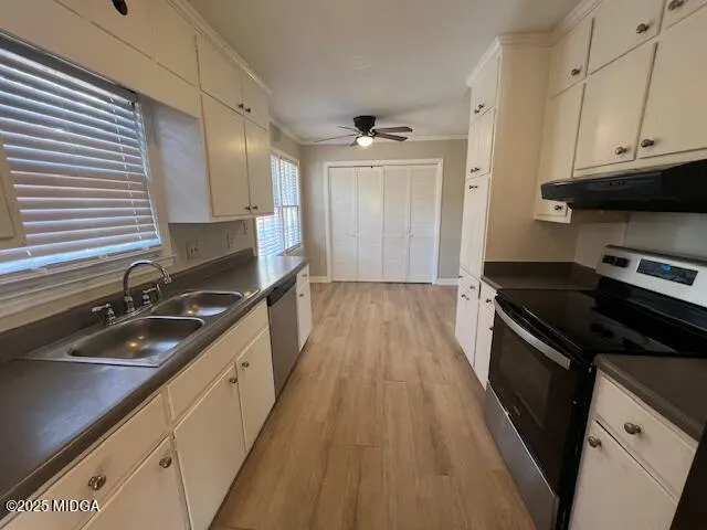 a kitchen with granite countertop stainless steel appliances a sink stove top oven and cabinets