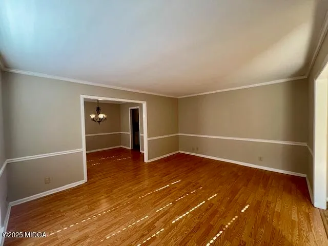 a view of an empty room with wooden floor and closet