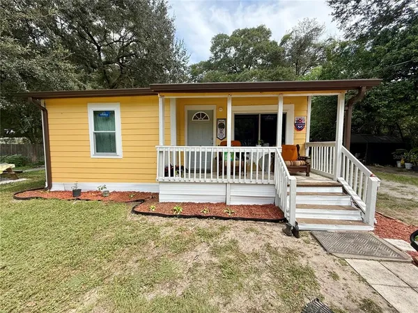 a view of a house with a small yard and wooden fence