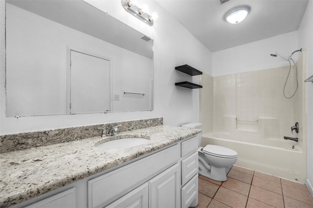 10121 Colony Drive Waco, TX 76708 - Photo 12 of 19 a bathroom with a granite countertop sink a toilet and bathtub