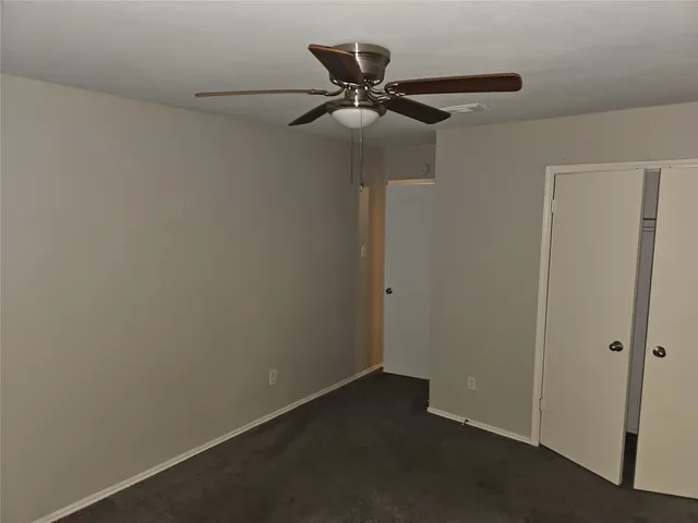 en empty room with windows and fan