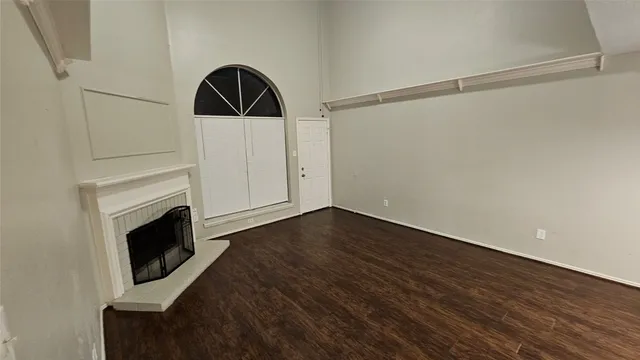 a living room with wooden floor and a fireplace