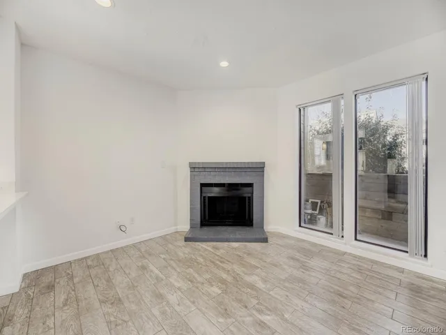 wooden floor fireplace and natural light in room