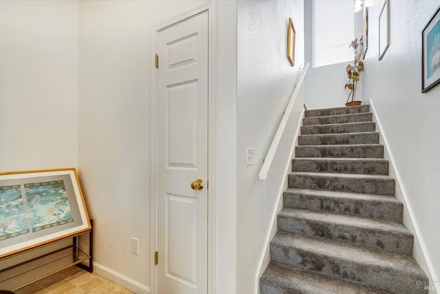 a view of staircase with wooden floor and white walls