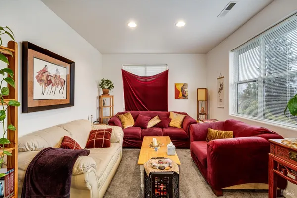 a living room with furniture and floor to ceiling windows
