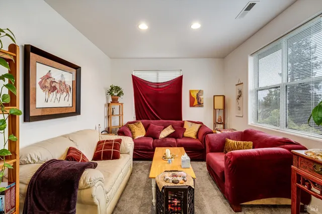 a living room with furniture and floor to ceiling windows