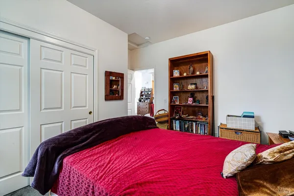 a bedroom with a bed a dresser and book shelf