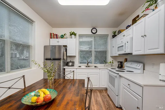 a kitchen with stainless steel appliances a stove a sink a refrigerator and a cabinets